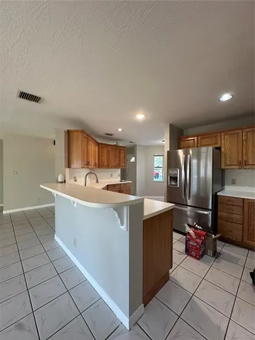 a kitchen with stainless steel appliances granite countertop a sink a stove a refrigerator a center island and cabinets