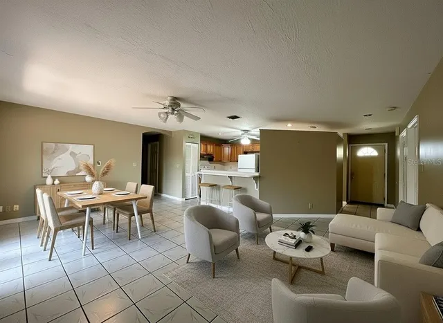 a living room with furniture and a dining table with kitchen view