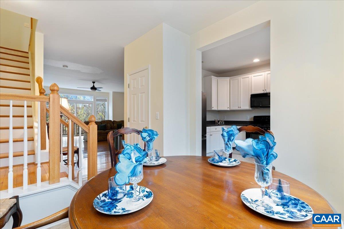 104 Melbourne Park Circle, Unit E Charlottesville, VA 22901 - Photo 17 of 33 a dining room with furniture a chandelier and kitchen view