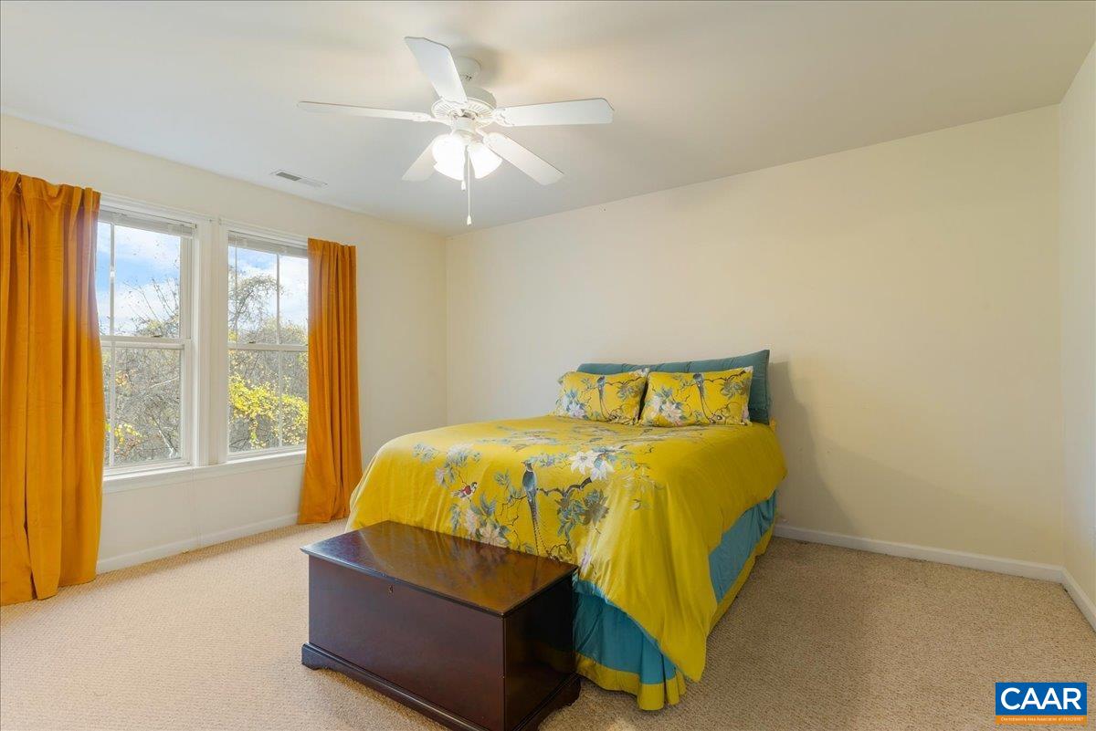 104 Melbourne Park Circle, Unit E Charlottesville, VA 22901 - Photo 27 of 33 a bed sitting in a bedroom next to a window