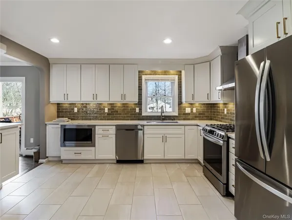 a kitchen with cabinets stainless steel appliances and window