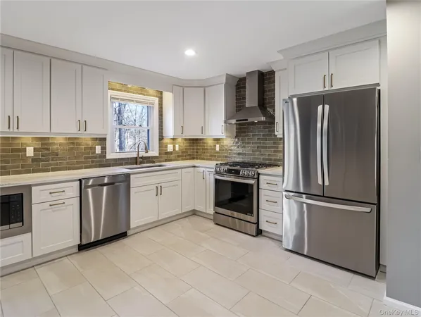 a kitchen with stainless steel appliances granite countertop a refrigerator stove and sink