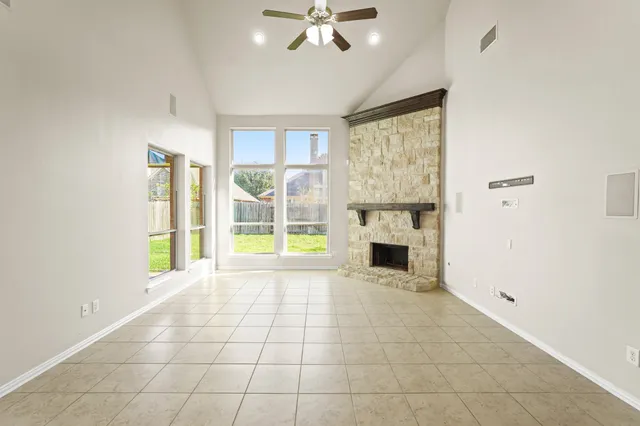 a view of an empty room with a fireplace and a window