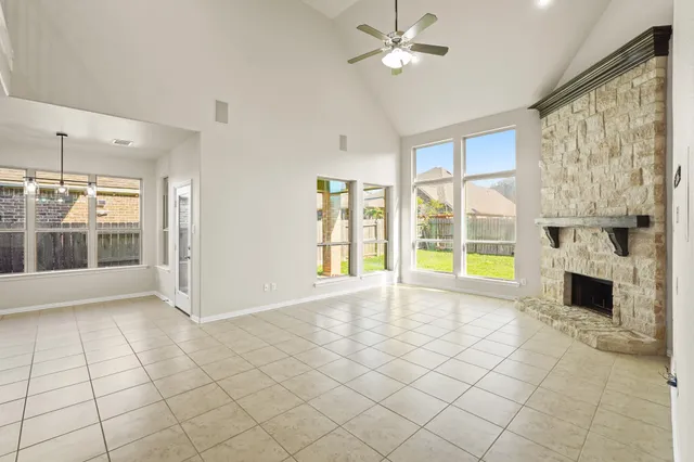 a view of an empty room with a fireplace and a large window