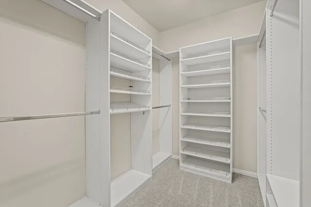 a view of walk in closet with empty racks