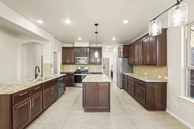 a large kitchen with stainless steel appliances lots of counter top space