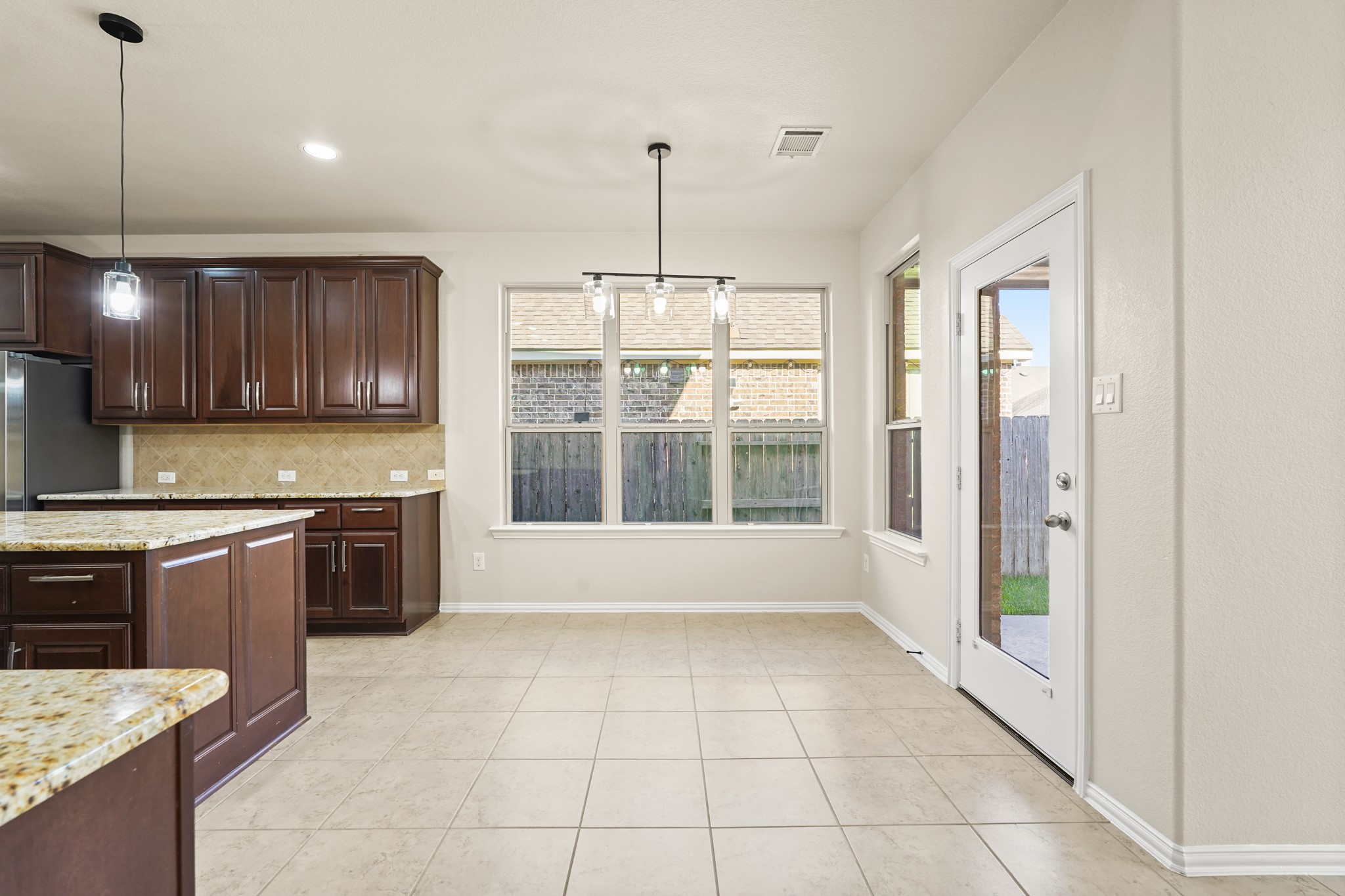 10335 Belvamera Road Richmond, TX 77407 - Photo 10 of 27 a large kitchen with granite countertop a stove a sink a counter space and cabinets