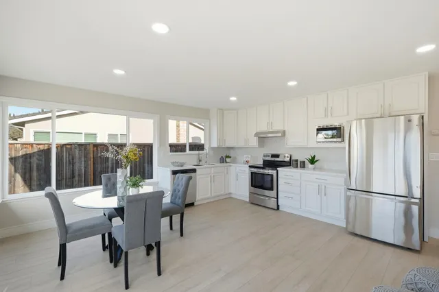a kitchen with refrigerator a sink and chairs