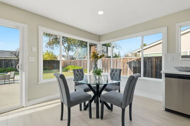 a view of a dining room with furniture large windows and wooden floor