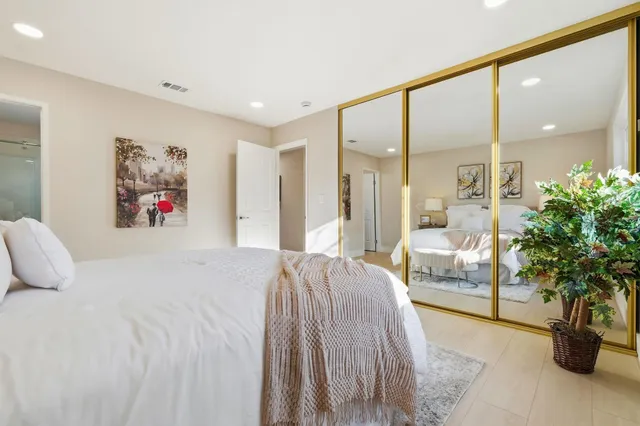 a bedroom with a large bed and a chandelier