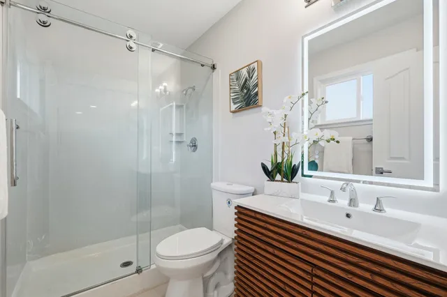 a bathroom with a sink toilet a mirror and shower
