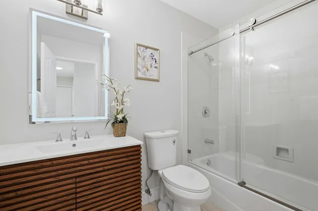 a bathroom with a sink a toilet and shower