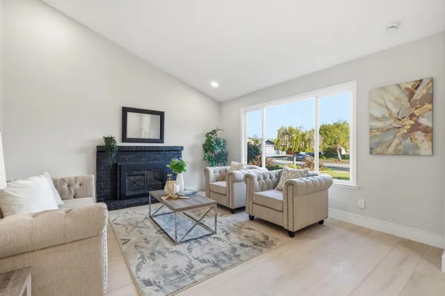 a living room with furniture a fireplace and a large window