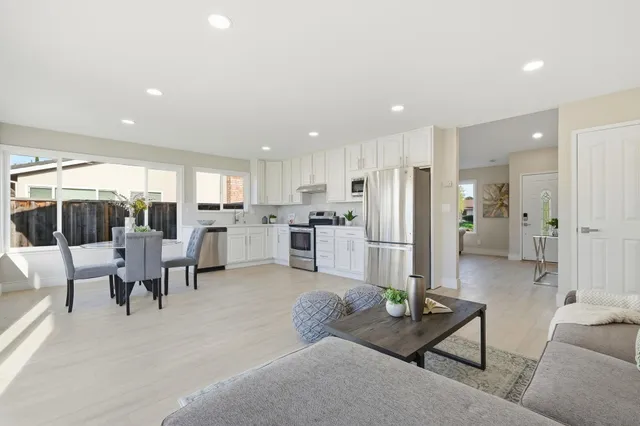 a living room with lots of furniture and kitchen view