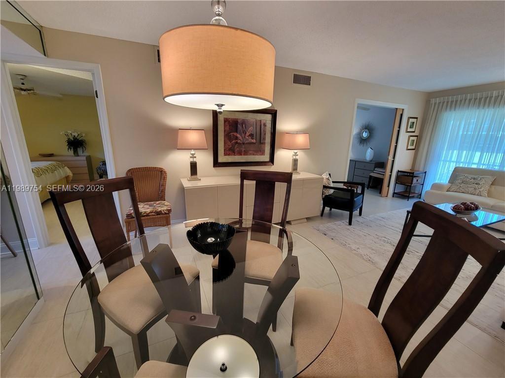 3774 Inverrary Boulevard, Unit 103P Lauderhill, FL 33319 - Photo 13 of 35 a view of a dining room with furniture and a chandelier
