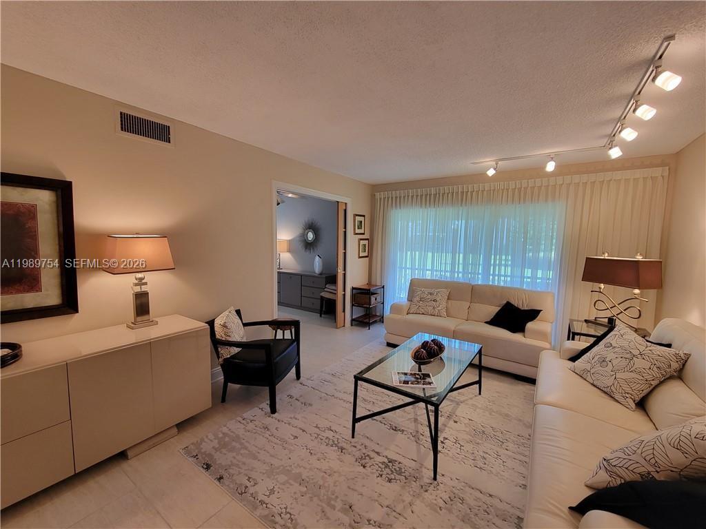 3774 Inverrary Boulevard, Unit 103P Lauderhill, FL 33319 - Photo 15 of 35 a living room with furniture and a lamp