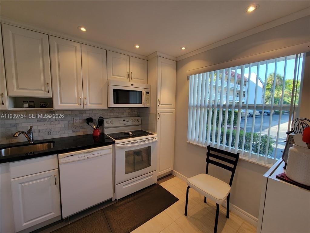 3774 Inverrary Boulevard, Unit 103P Lauderhill, FL 33319 - Photo 16 of 35 a kitchen with a stove a sink and a microwave
