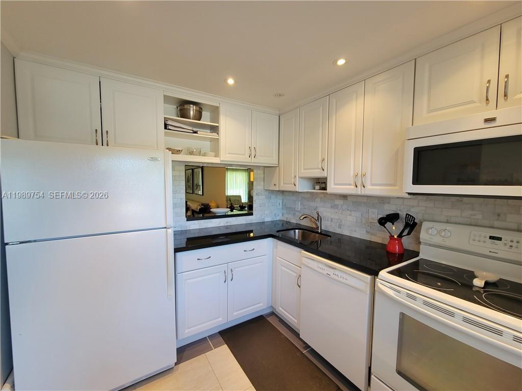 3774 Inverrary Boulevard, Unit 103P Lauderhill, FL 33319 - Photo 17 of 35 a kitchen with a sink a refrigerator and cabinets