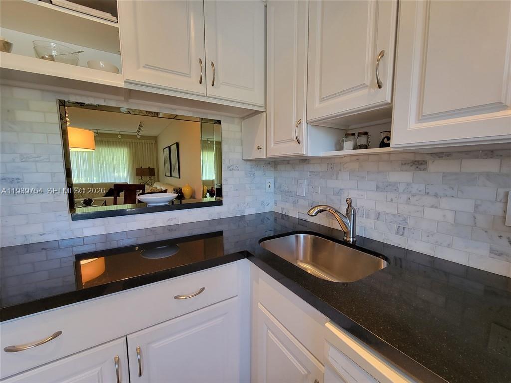 3774 Inverrary Boulevard, Unit 103P Lauderhill, FL 33319 - Photo 19 of 35 a kitchen with granite countertop a sink and a white cabinets
