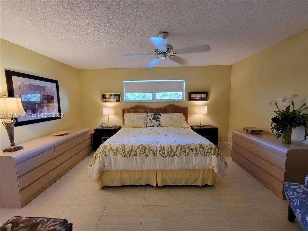 3774 Inverrary Boulevard, Unit 103P Lauderhill, FL 33319 - Photo 22 of 35 a bedroom with a bed and a chandelier