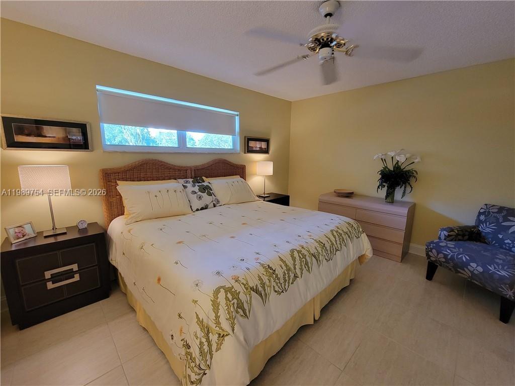 3774 Inverrary Boulevard, Unit 103P Lauderhill, FL 33319 - Photo 24 of 35 a bedroom with a bed and ceiling fan