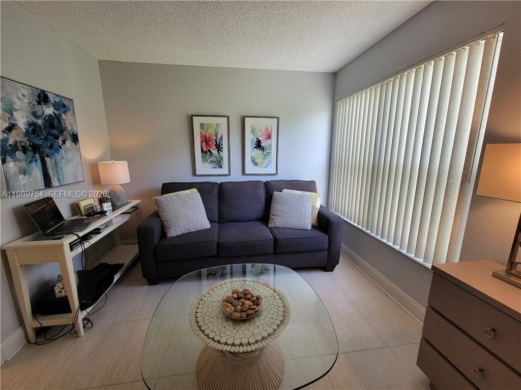 3774 Inverrary Boulevard, Unit 103P Lauderhill, FL 33319 - Photo 25 of 35 a living room with furniture and a window