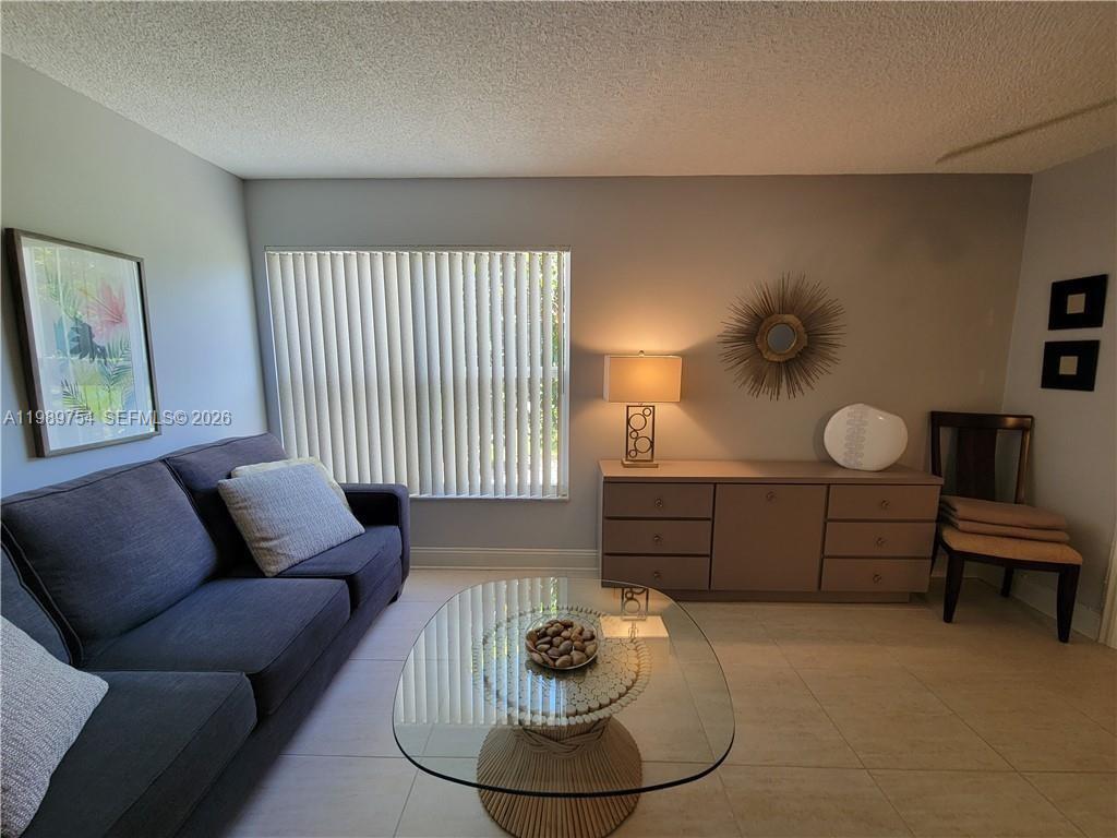 3774 Inverrary Boulevard, Unit 103P Lauderhill, FL 33319 - Photo 28 of 35 a living room with furniture and a window