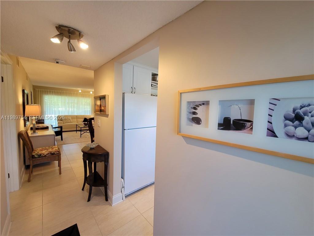 3774 Inverrary Boulevard, Unit 103P Lauderhill, FL 33319 - Photo 30 of 35 a living room with furniture and a refrigerator