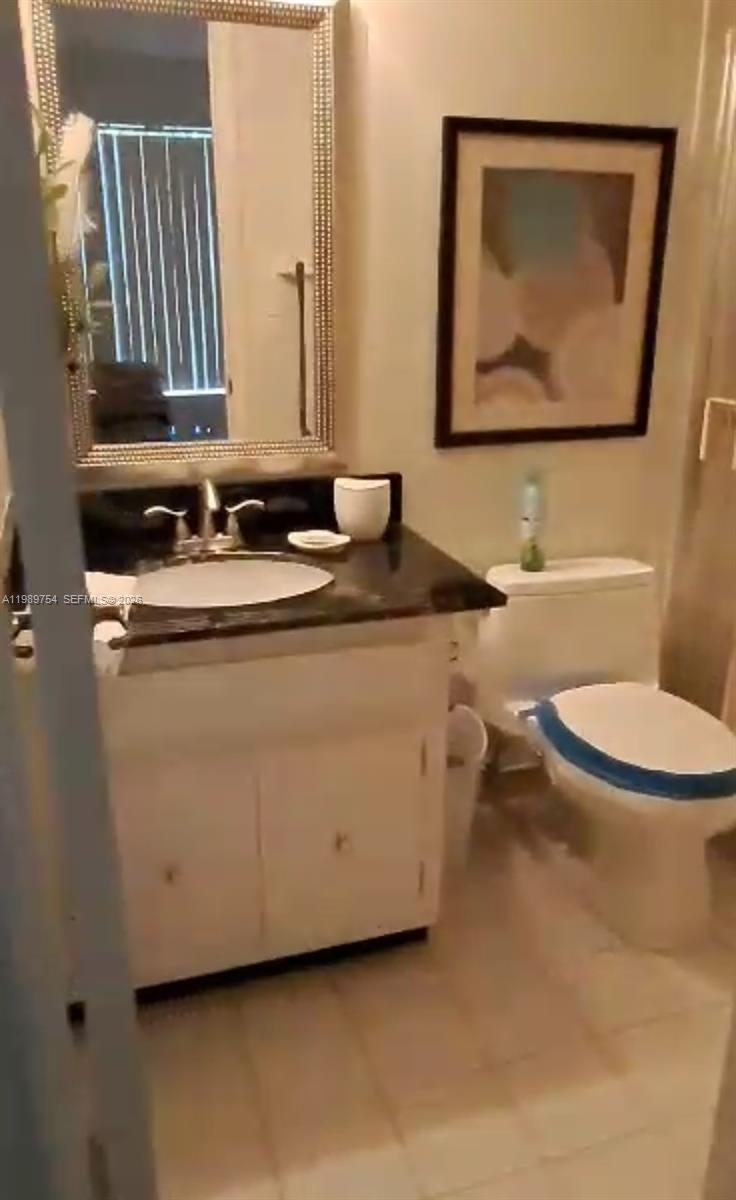 3774 Inverrary Boulevard, Unit 103P Lauderhill, FL 33319 - Photo 3 of 35 a bathroom with a granite countertop toilet sink and mirror