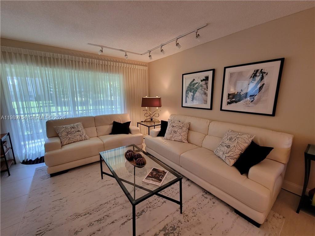 3774 Inverrary Boulevard, Unit 103P Lauderhill, FL 33319 - Photo 7 of 35 a living room with furniture and a large window