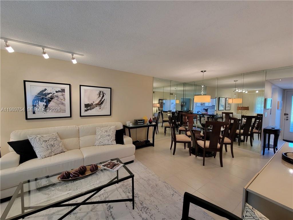 3774 Inverrary Boulevard, Unit 103P Lauderhill, FL 33319 - Photo 9 of 35 a living room with furniture and a dining table with kitchen view