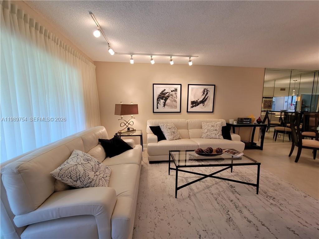 3774 Inverrary Boulevard, Unit 103P Lauderhill, FL 33319 - Photo 10 of 35 a living room with furniture and wooden floor