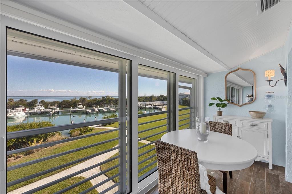 5854 Gasparilla Road, Unit MV20 Boca Grande, FL 33921 - Photo 23 of 49 a view of a dining room with furniture window and wooden floor