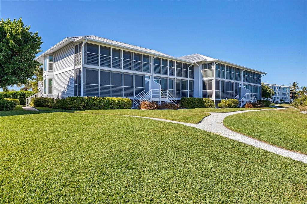 5854 Gasparilla Road, Unit MV20 Boca Grande, FL 33921 - Photo 26 of 49 a front view of a building with garden and trees