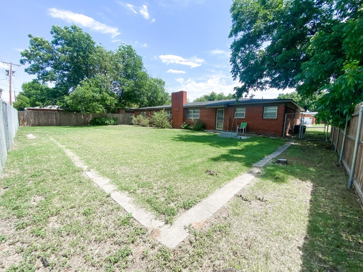 4010 47th Street Lubbock, TX 79413 - Photo 18 of 20 a backyard of a house with plants and large tree