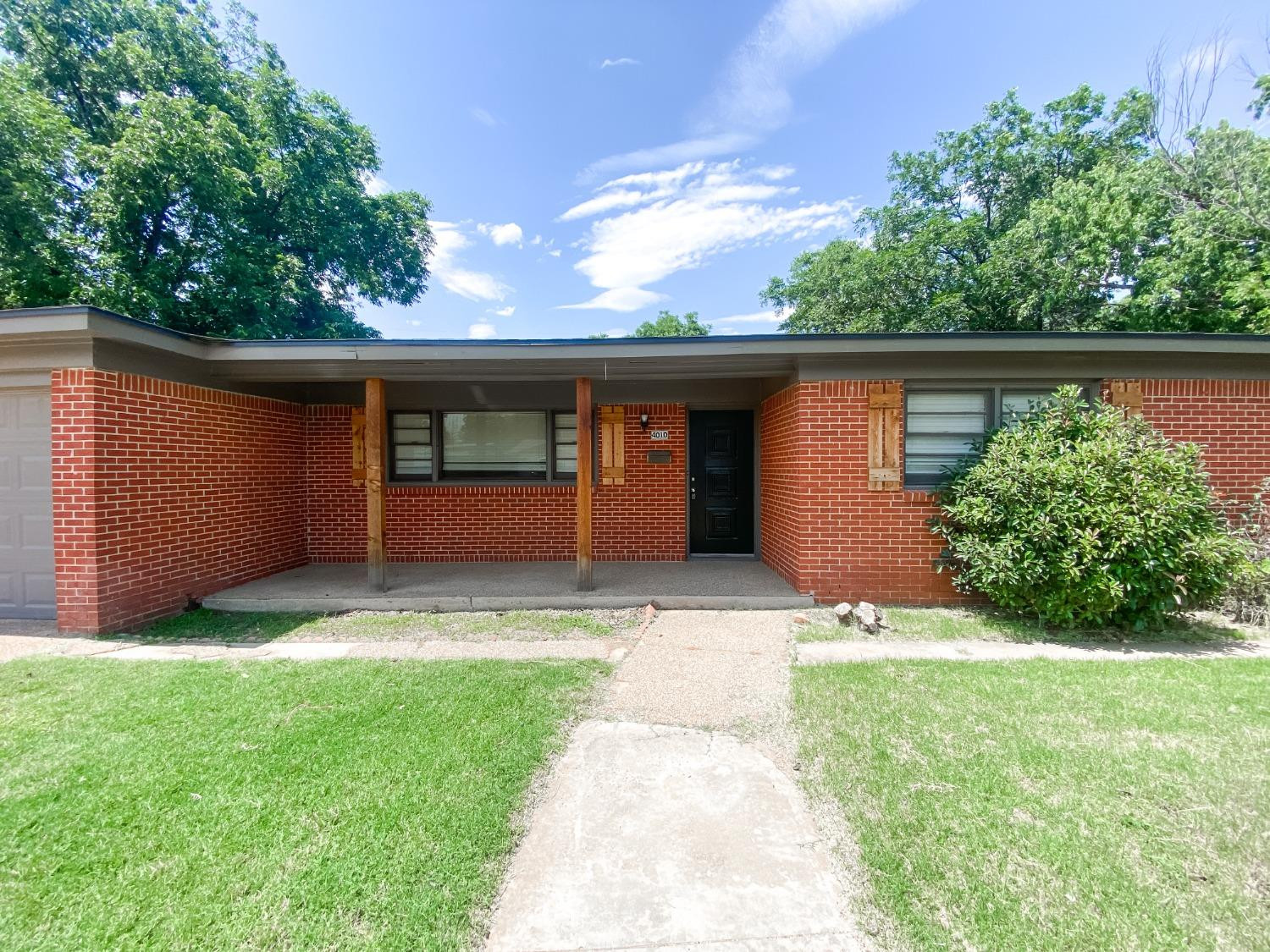 4010 47th Street Lubbock, TX 79413 - Photo 2 of 20 a front view of a house with a yard and garage