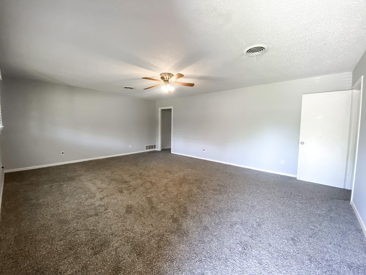 4010 47th Street Lubbock, TX 79413 - Photo 4 of 20 a view of an empty room with a chandelier fan
