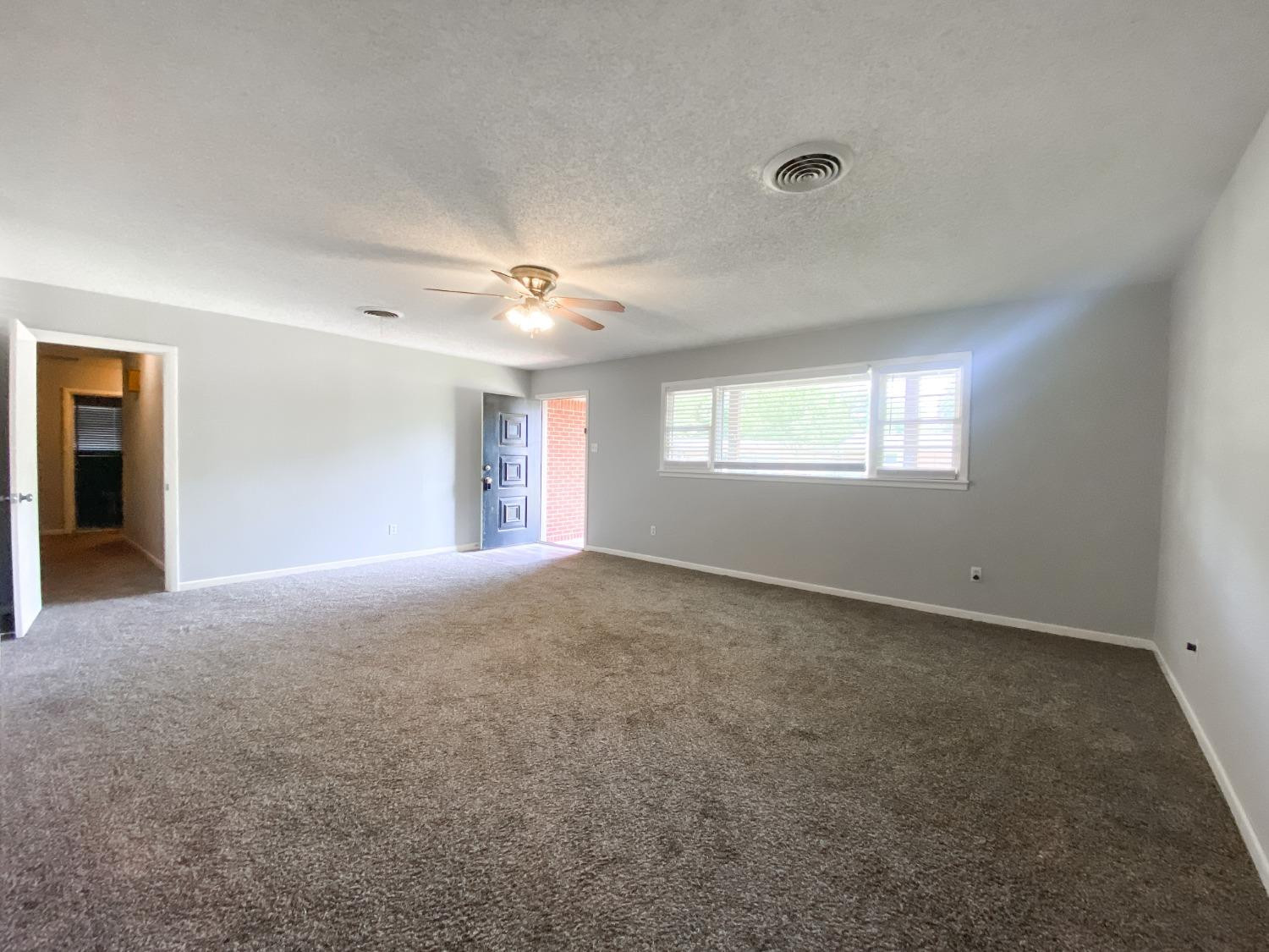 4010 47th Street Lubbock, TX 79413 - Photo 5 of 20 a view of an empty room with window and chandelier fan
