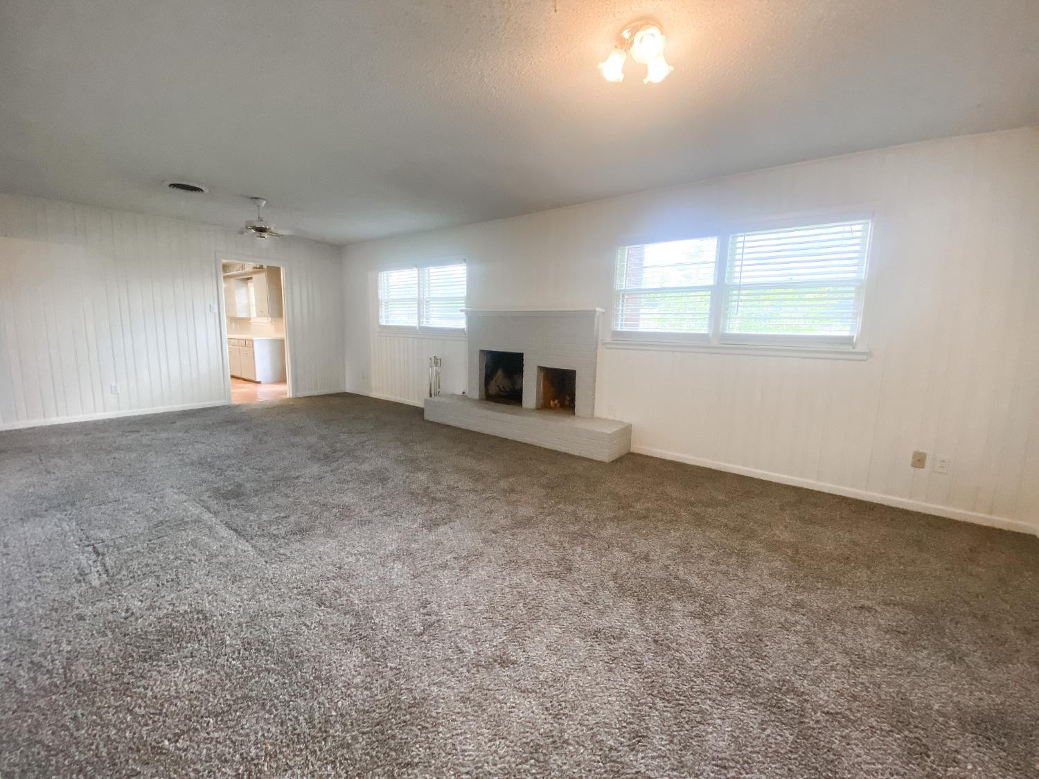 4010 47th Street Lubbock, TX 79413 - Photo 6 of 20 an empty room with windows and fireplace