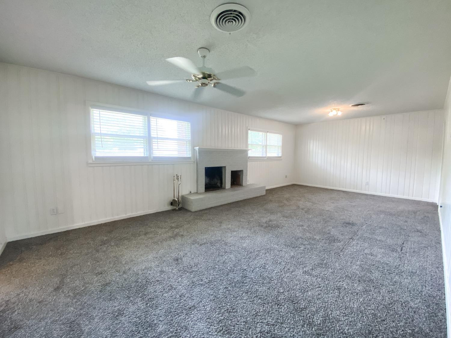 4010 47th Street Lubbock, TX 79413 - Photo 7 of 20 a view of an empty room with a fireplace and a window