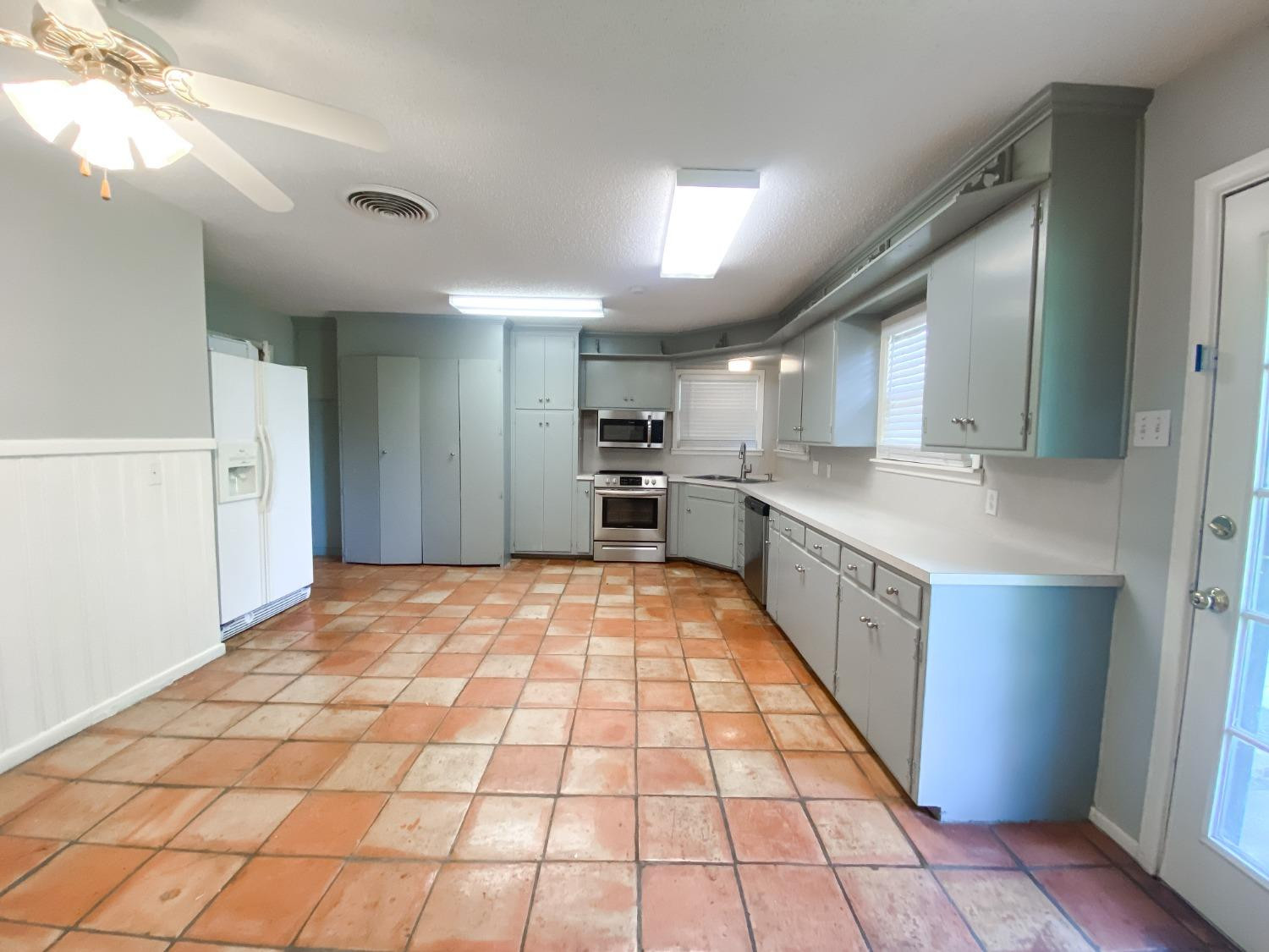 4010 47th Street Lubbock, TX 79413 - Photo 9 of 20 a large kitchen with stainless steel appliances granite countertop a refrigerator and a stove top oven