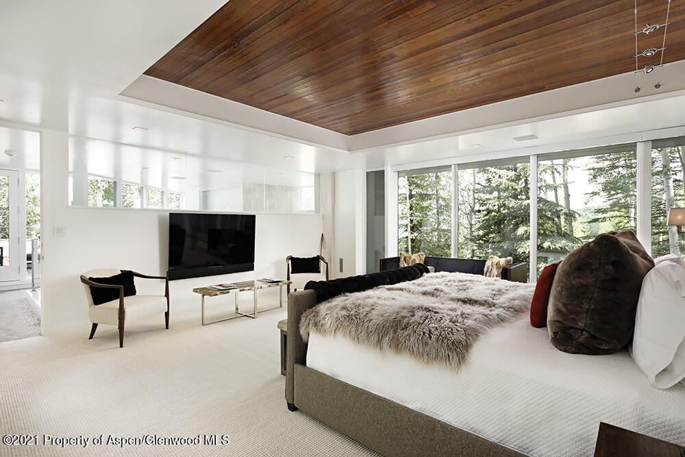 546 Edgewood Lane Snowmass Village, CO 81615 - Photo 15 of 60 a spacious bedroom with a bed and a flat screen tv