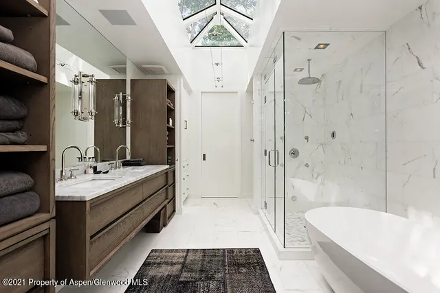 a bathroom with a double vanity sink and large mirror