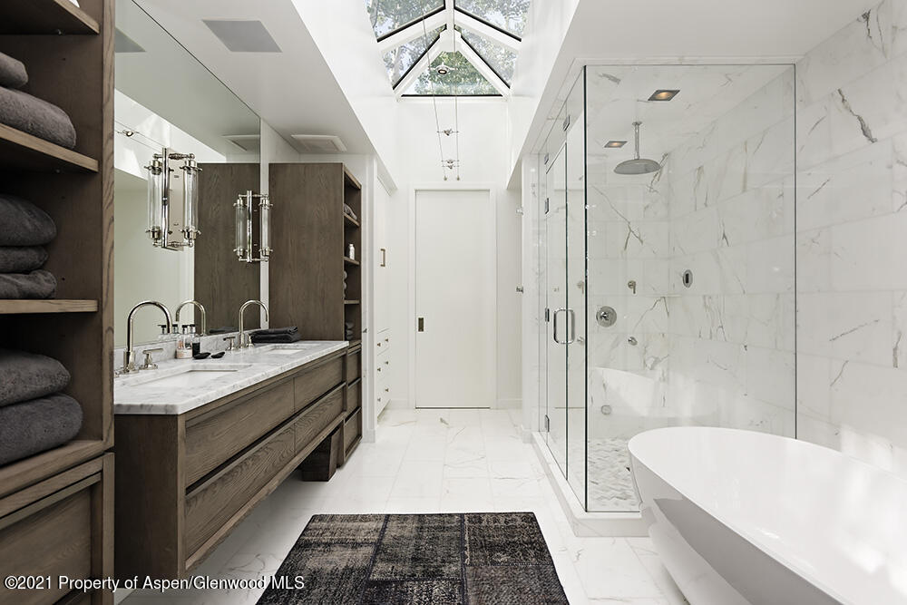 546 Edgewood Lane Snowmass Village, CO 81615 - Photo 17 of 60 a bathroom with a double vanity sink a large mirror and a bathtub