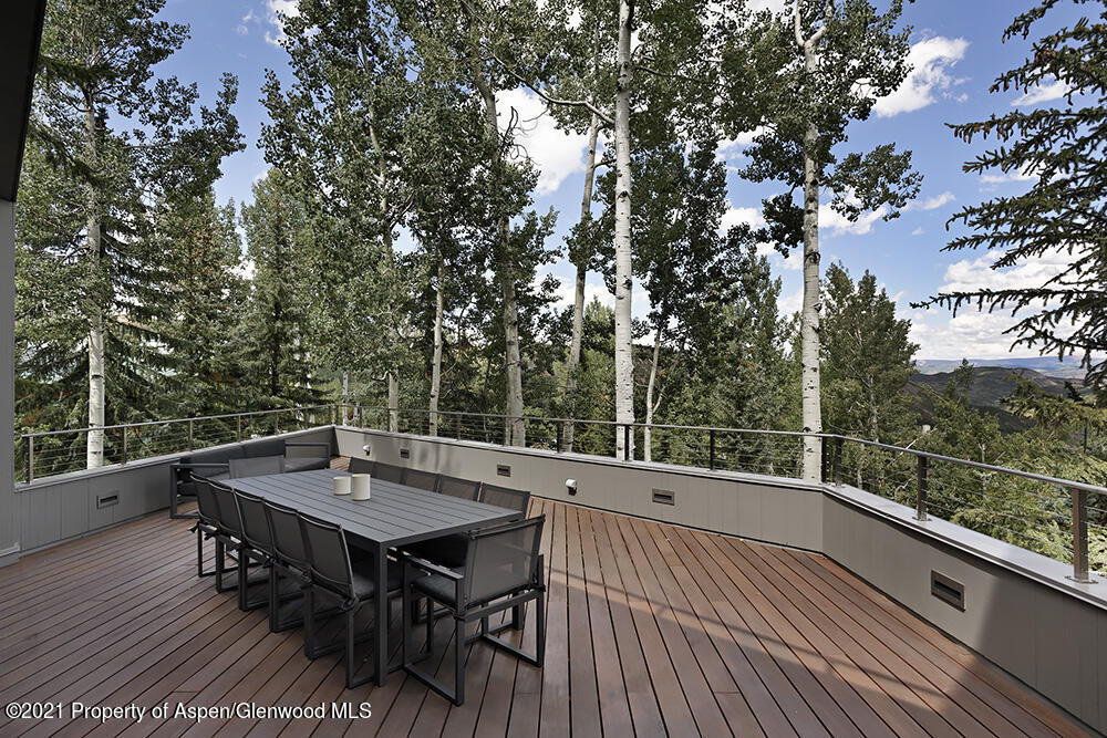 546 Edgewood Lane Snowmass Village, CO 81615 - Photo 45 of 60 a view of a roof deck with table and chairs a barbeque with wooden floor and fence