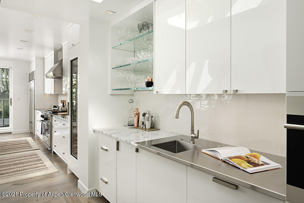 546 Edgewood Lane Snowmass Village, CO 81615 - Photo 10 of 60 a kitchen with stainless steel appliances a sink a stove and a wooden floor