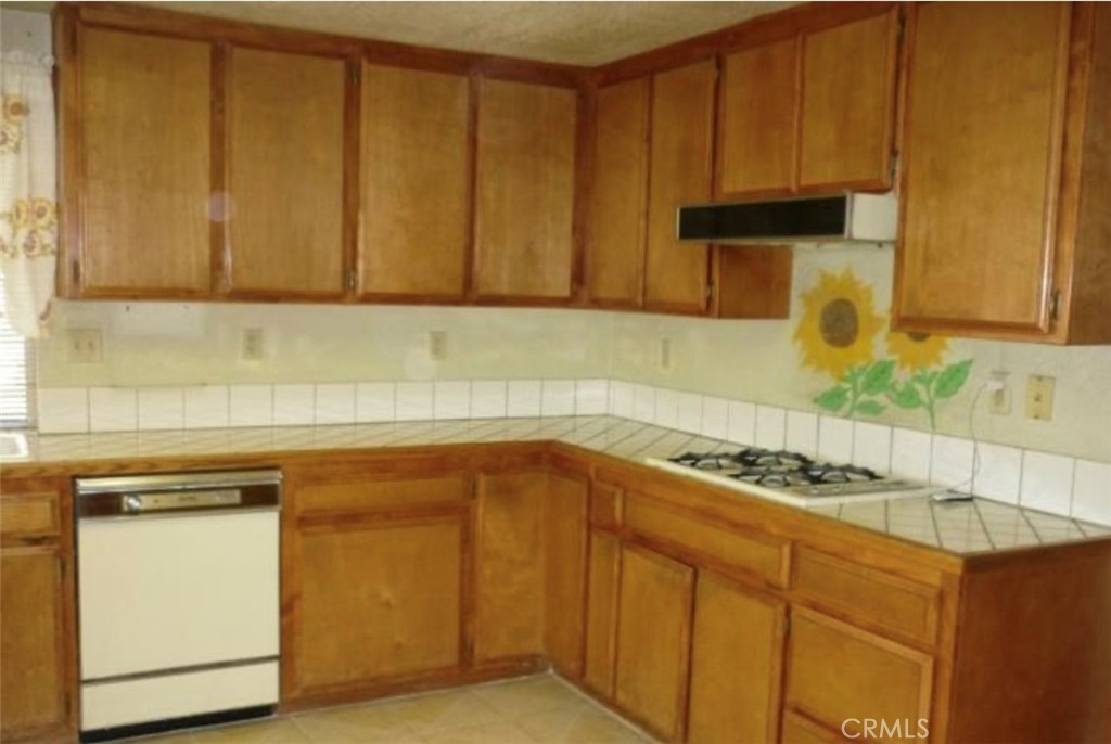 6888 Bookasta Street Adelanto, CA 92301 - Photo 10 of 19 a kitchen with stainless steel appliances granite countertop a sink stove and cabinets