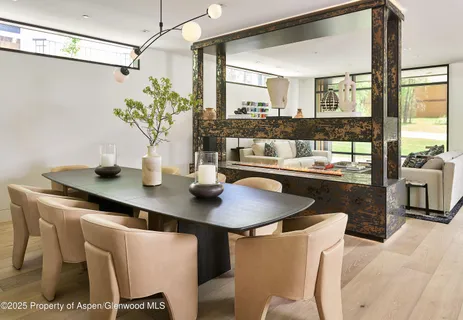 a dining room with furniture and a potted plant