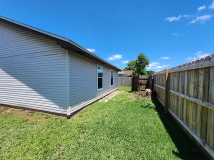 a view of a backyard with wooden fence