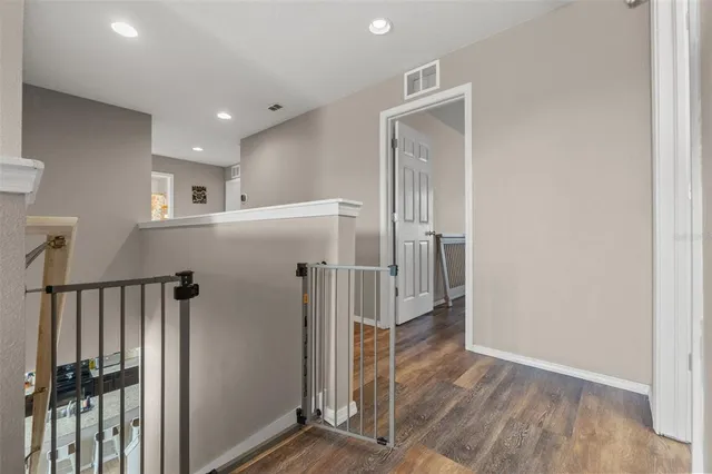 a view of a hallway with wooden floor and staircase